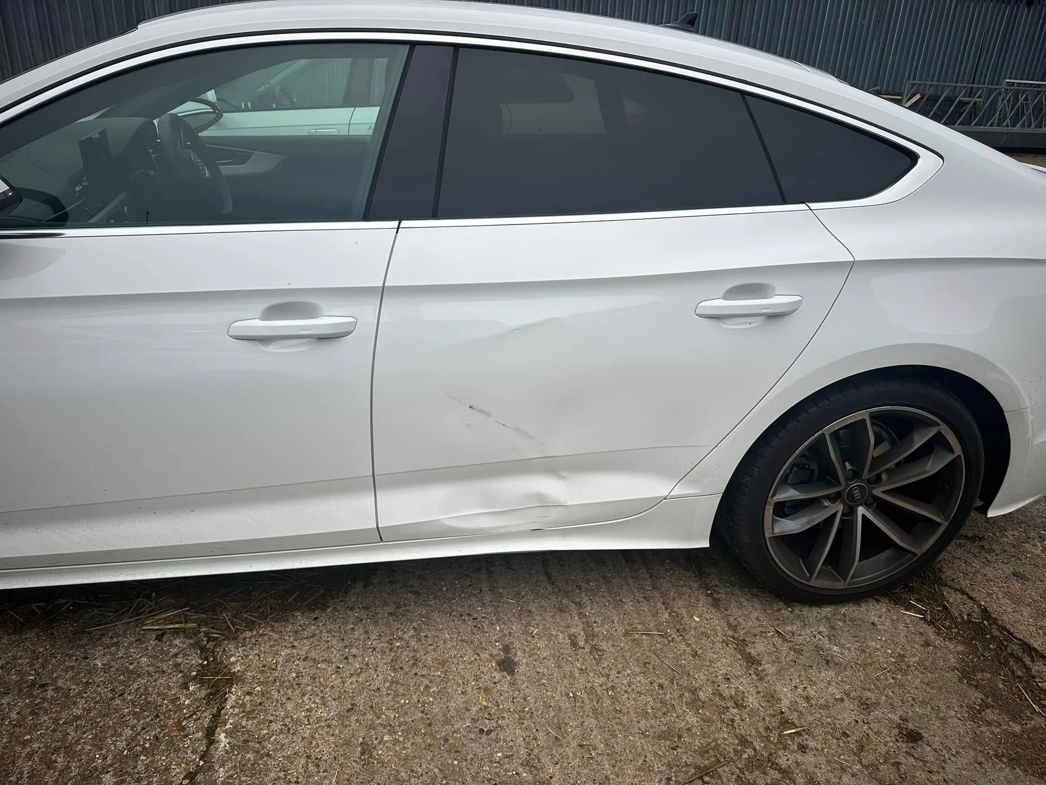 A white car parked in front of a building.