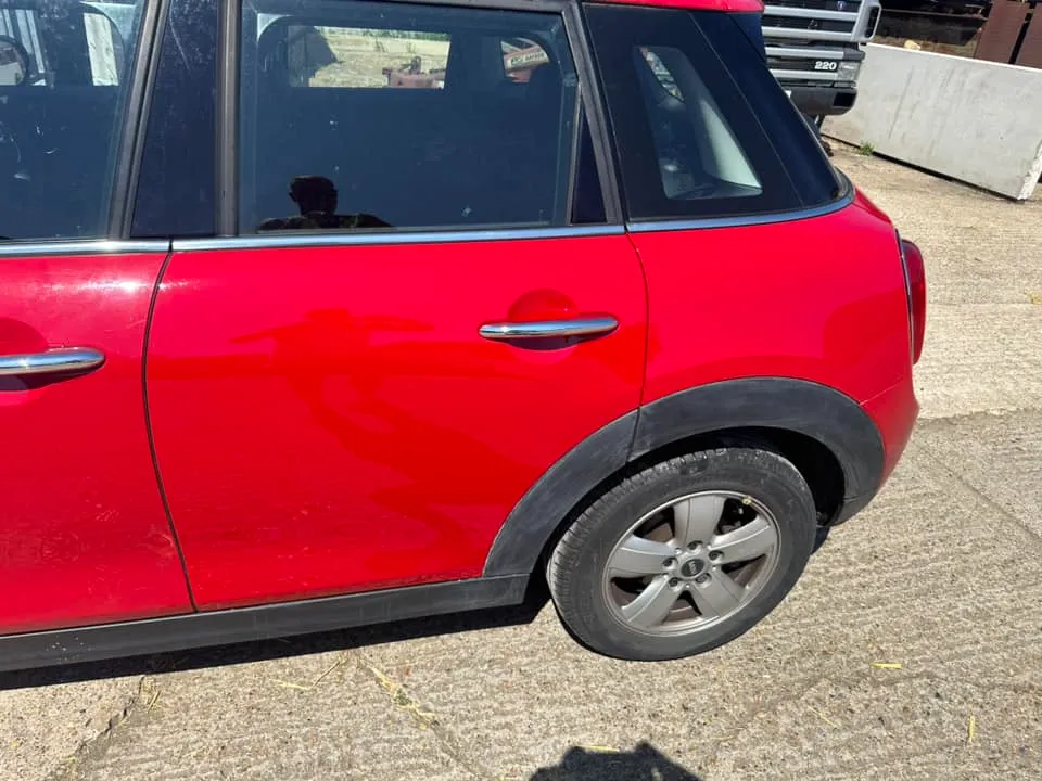 A small red car parked on the side of the road.