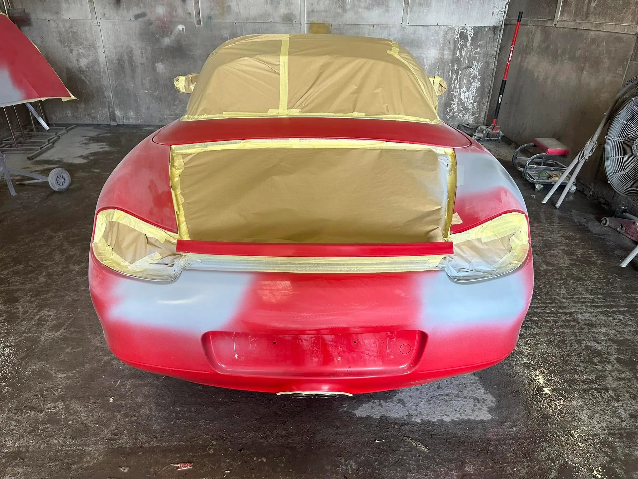 A red and yellow car in a garage.