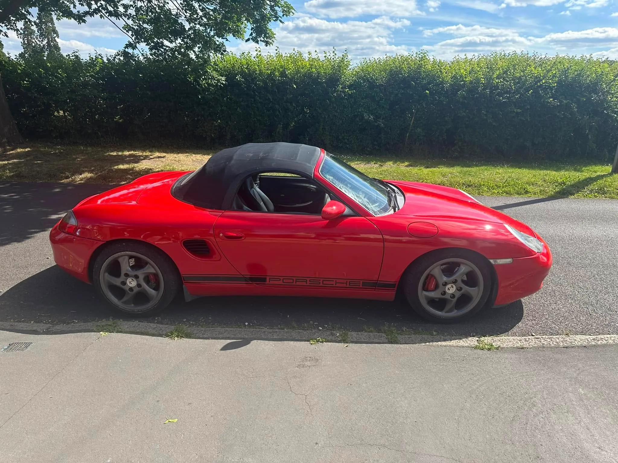 A red sports car parked on the side of the road.