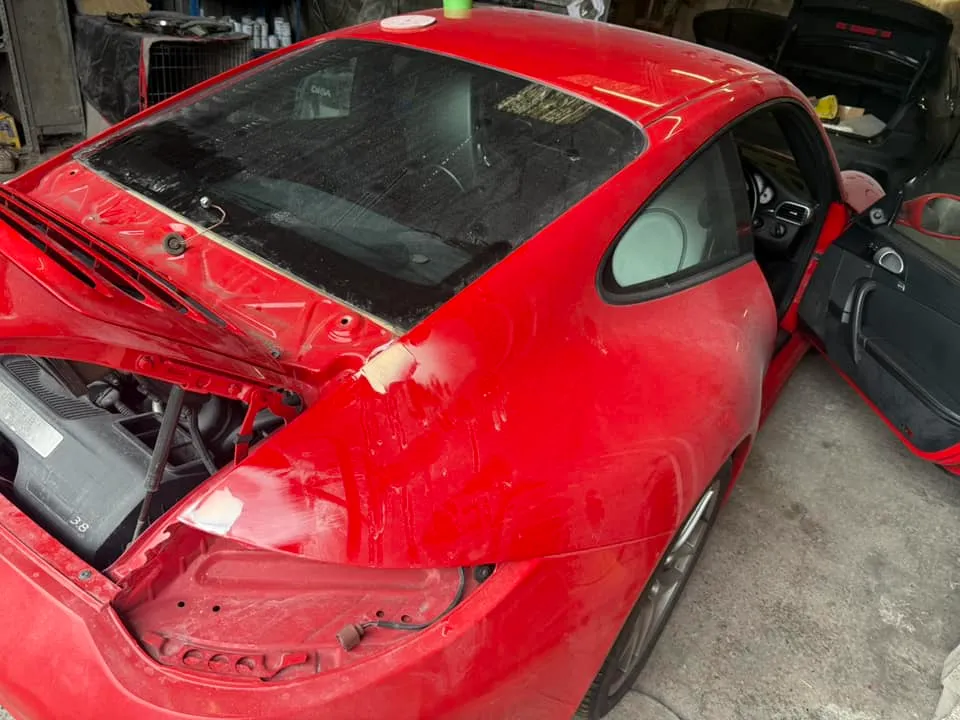 A red sports car with its hood open.
