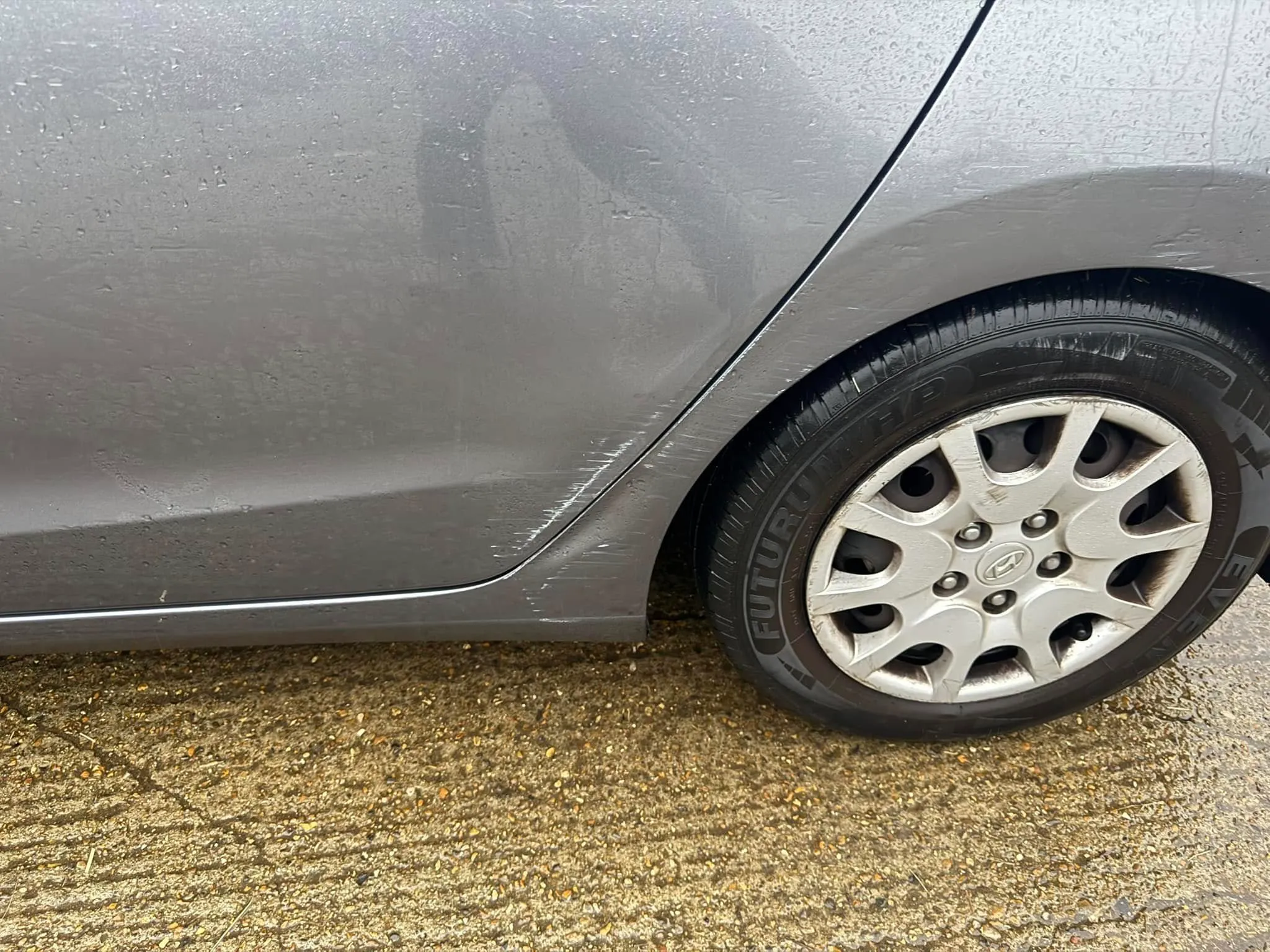 A close up of a car tire on a wet road.