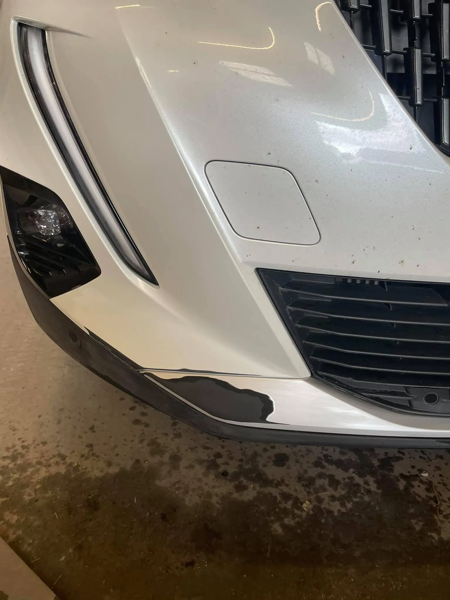 A close up of the front of a white sports car.