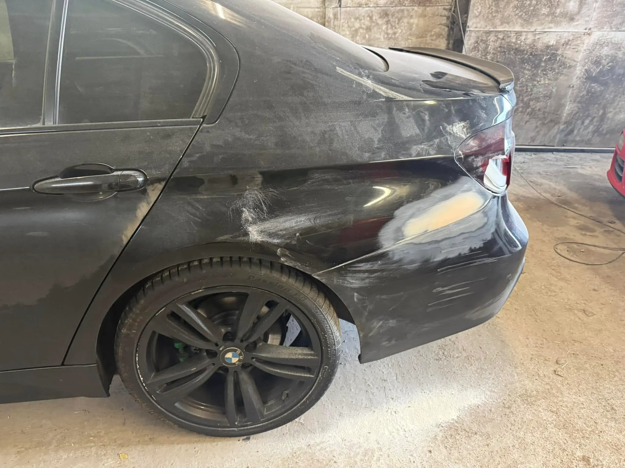 A black car with a dented front bumper.