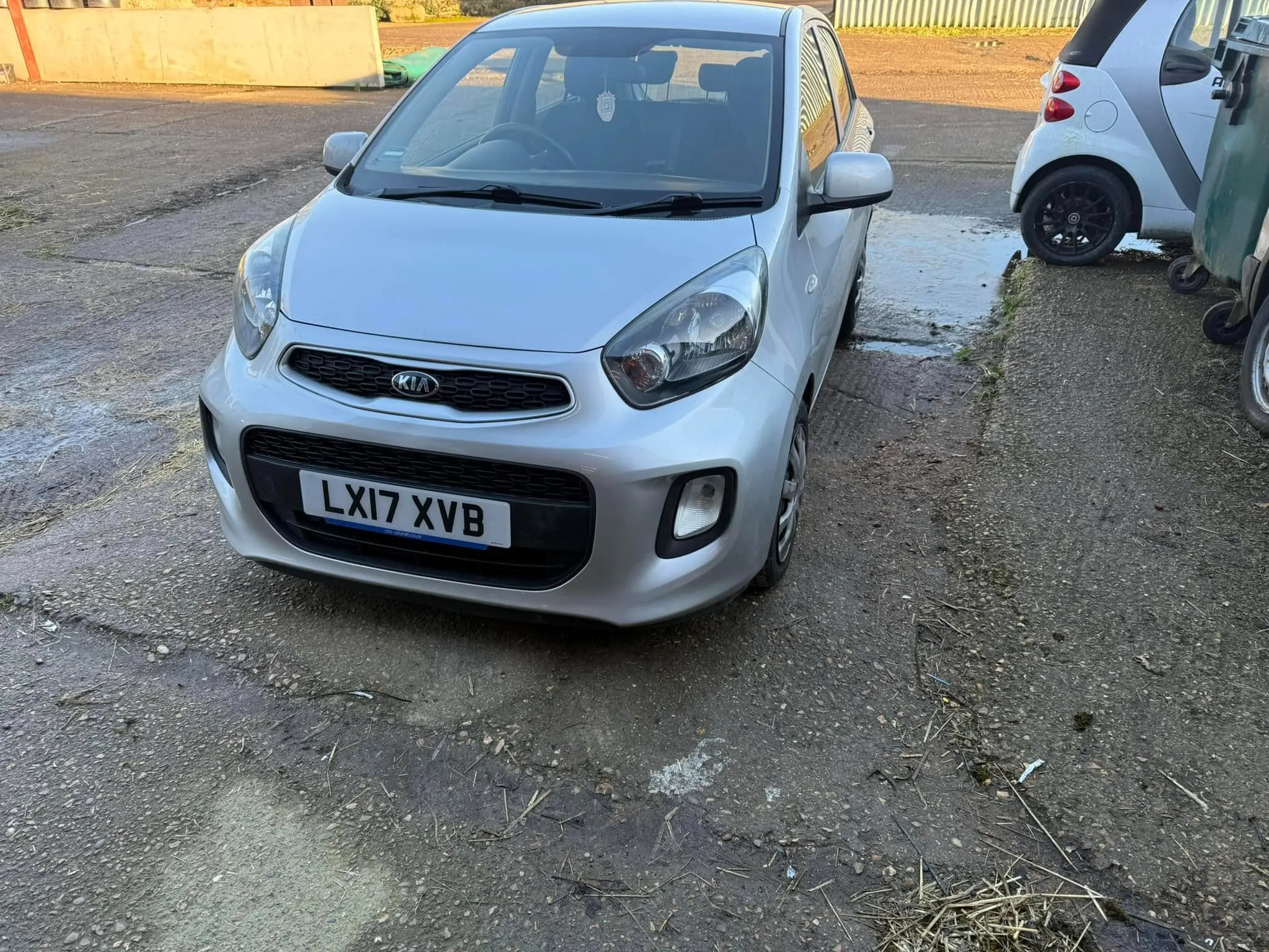 A small silver car parked in a parking lot.