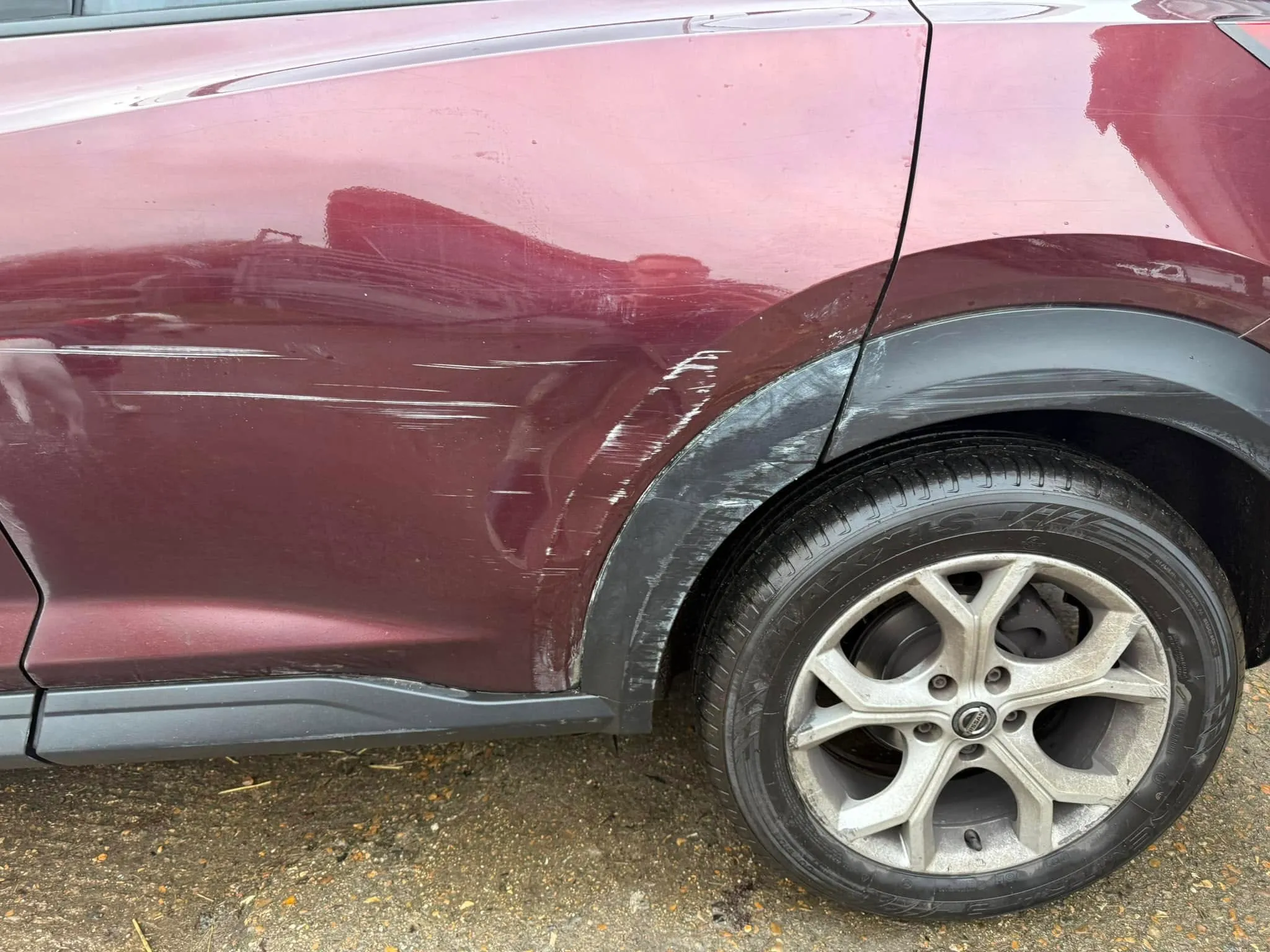 A close up of the side of a red car.