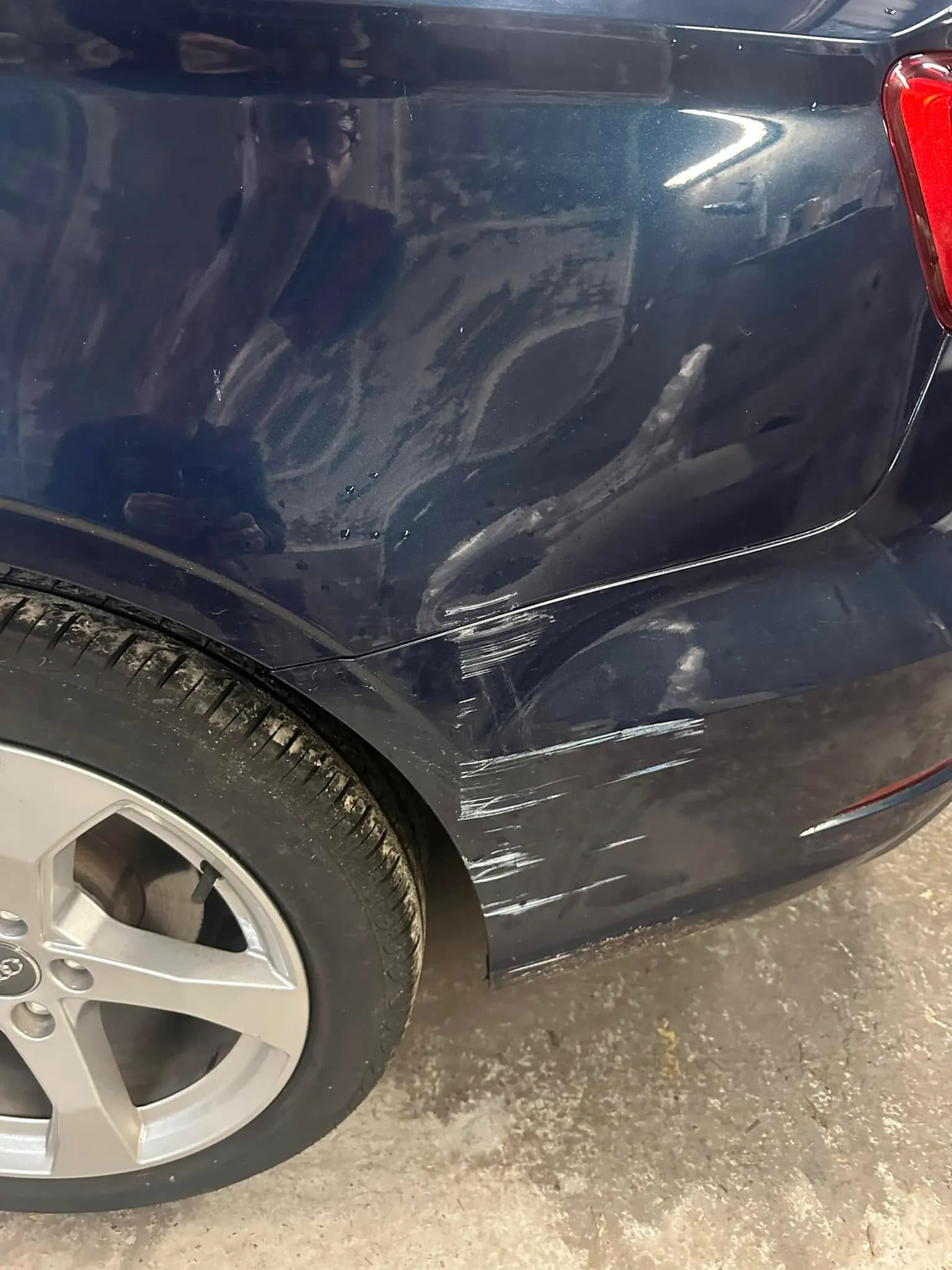 A close up of a blue car parked in a parking lot.