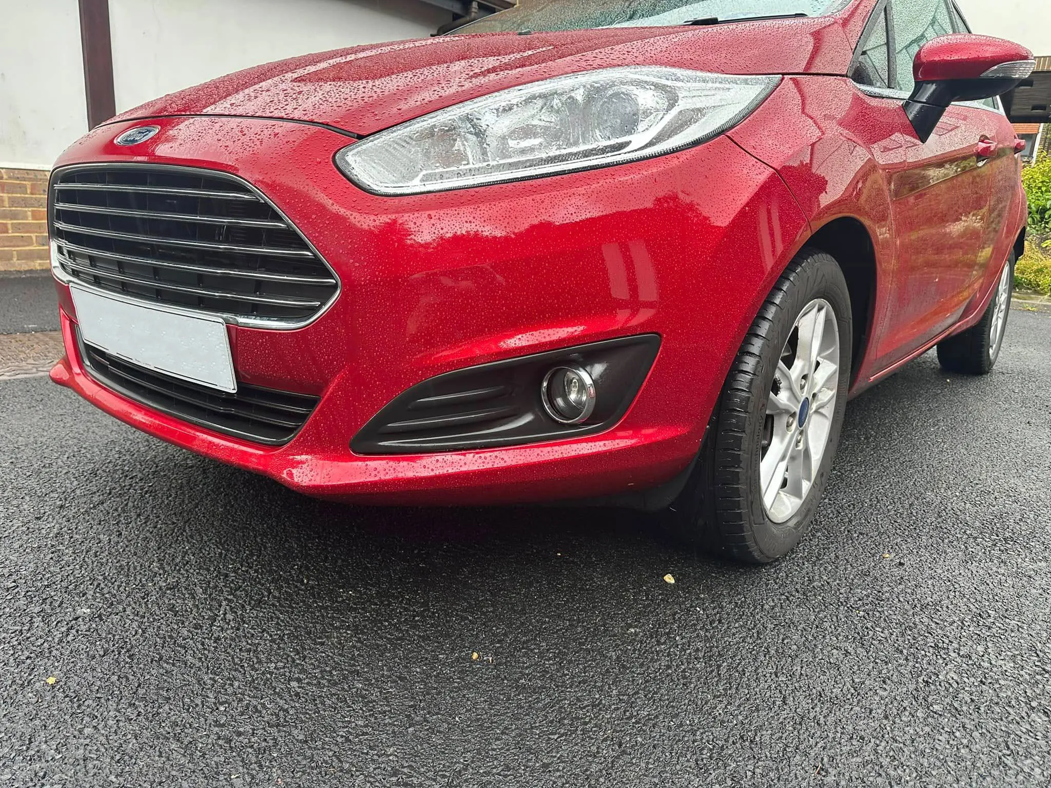 A red car parked in front of a building.